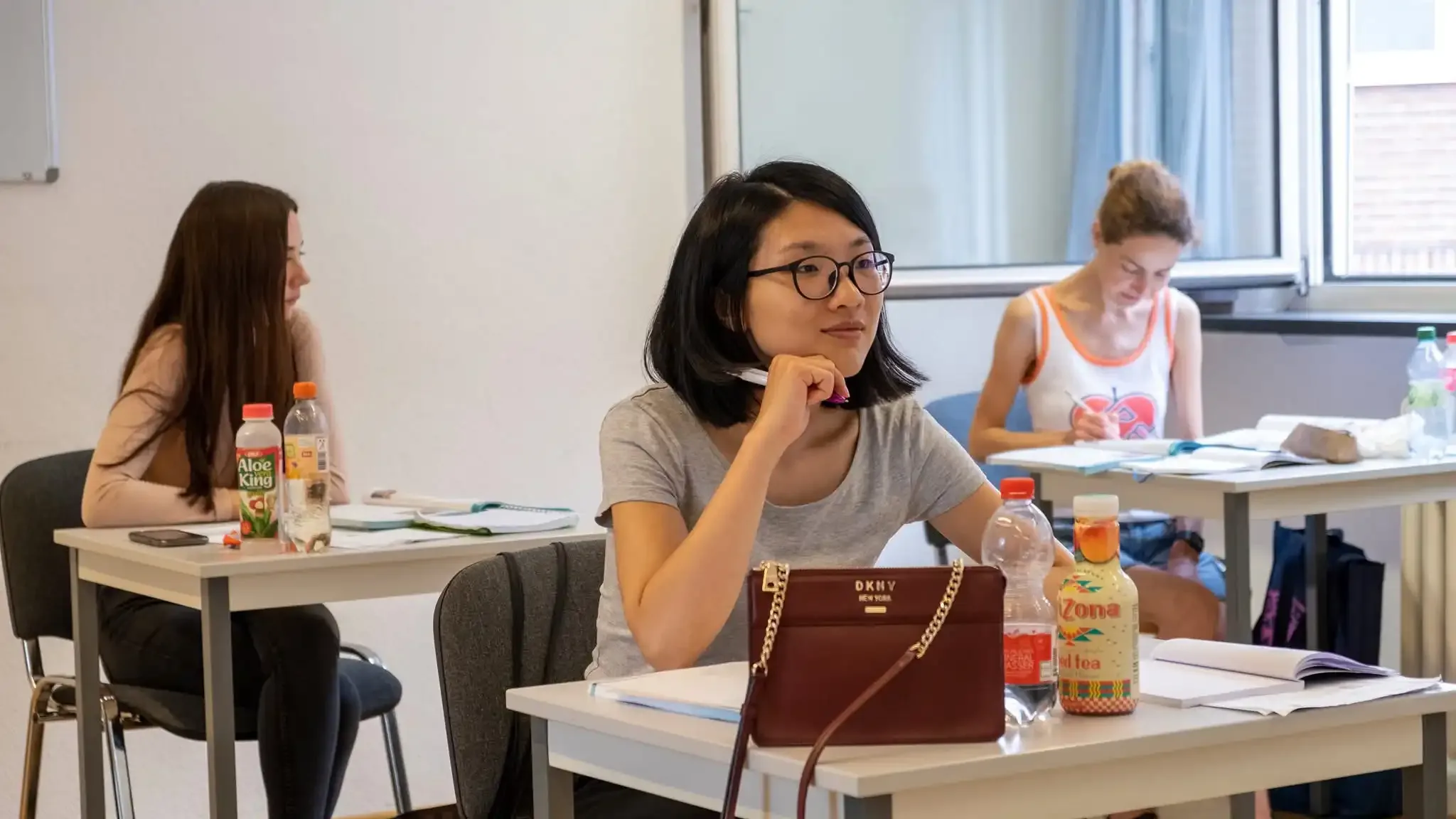 Eine Studentin hört im Deutschunterricht aufmerksam zu